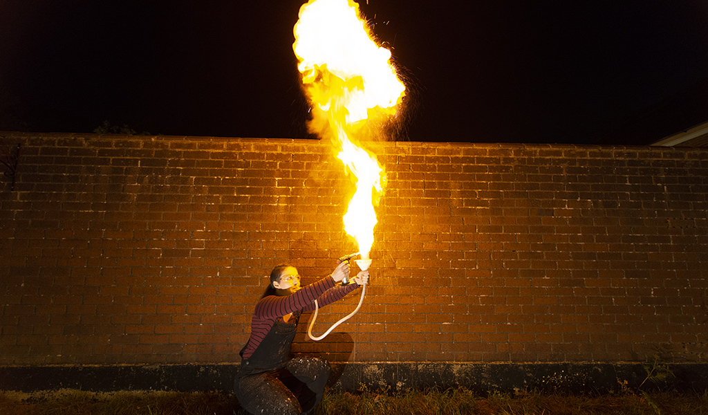 Natasha ignites a cloud of flour from a funnel.